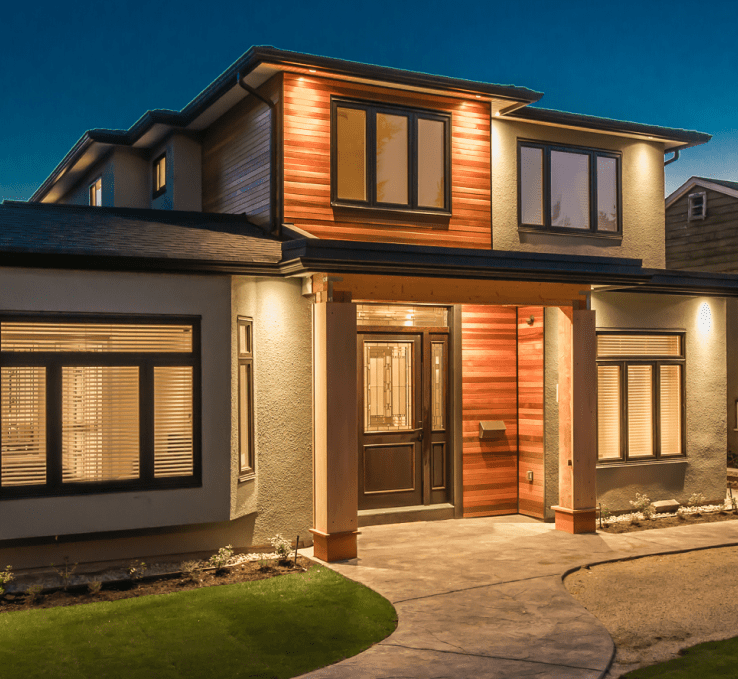 Picture of luxury home lit up at dusk with potlights